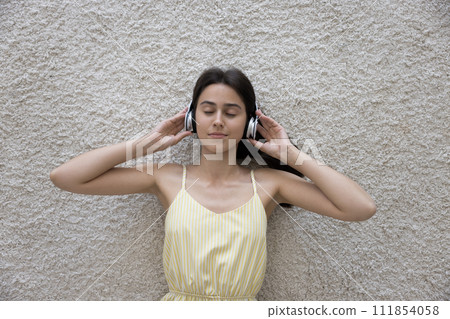Above view pretty woman enjoy quality sound through wireless headphones 111854058
