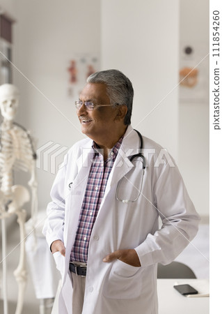 Happy elder Indian medical therapist man thinking on successful treatment Happy elder Indian medical therapist man thinking on successful treatment 111854260