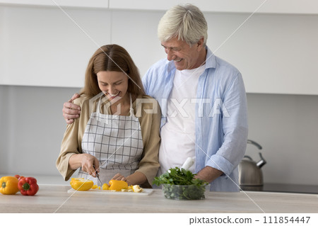 Millennial woman helps with dinner to elderly hoary father Millennial woman helps with dinner to elderly hoary father 111854447