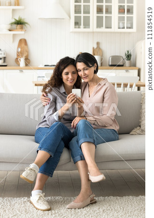 Multigenerational women, mom and daughter doing online shopping using cellphone 111854519