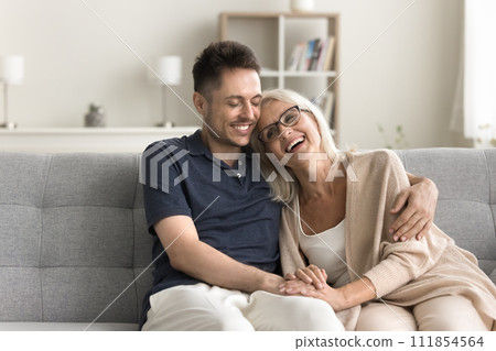 Cheerful mature mother and adult child man sitting together 111854564