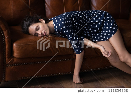 Exhausted woman lying on couch, sleeping after long workday Exhausted woman lying on couch, sleeping after long workday 111854568