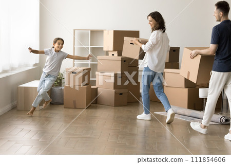 Cheerful parents and running kid girl moving into new home 111854606