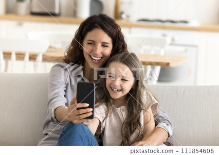 Happy mother cuddling daughter taking selfie picture on smartphone camera 111854608