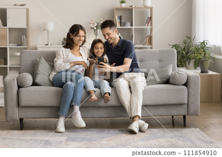 Happy young couple and little kid talking on video call Happy young couple and little kid talking on video call 111854910