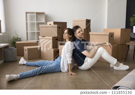 Tired exhausted young couple of home owners sitting on floor 111855130