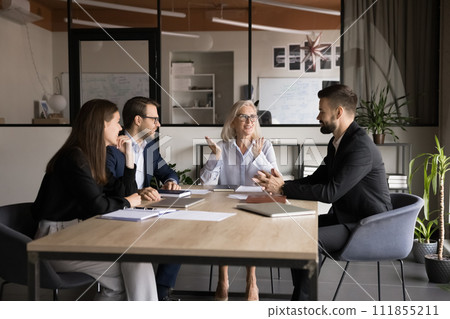 Senior company owner woman talking to team of younger managers 111855211