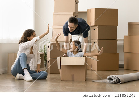 Happy mom, dad and excited playful child enjoying moving Happy mom, dad and excited playful child enjoying moving 111855245