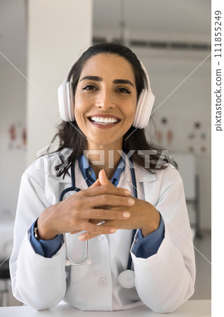 Positive young Latin doctor woman giving online professional consultation Positive young Latin doctor woman giving online professional consultation 111855249