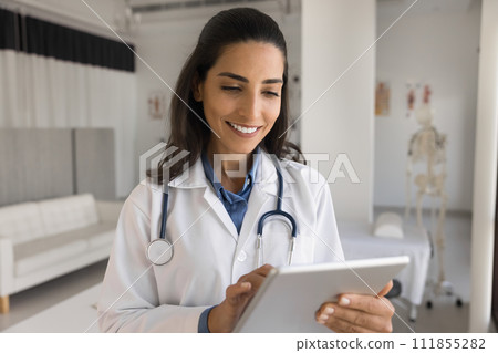 Happy young beautiful doctor woman using tablet for online communication 111855282