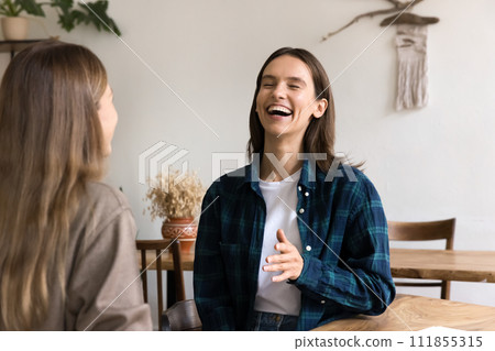 Two happy young female friends meeting at table Two happy young female friends meeting at table 111855315