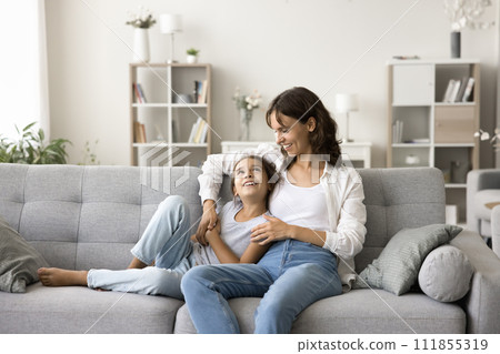 Happy young mom and cute little daughter resting on couch 111855319