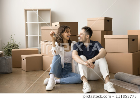 Happy excited young married couple enjoying moving process Happy excited young married couple enjoying moving process 111855773