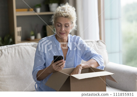 Positive mature woman hold cellphone use express transportation logistic service Positive mature woman hold cellphone use express transportation logistic service 111855931