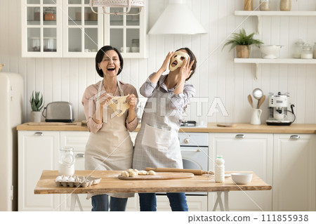Family joking, laughing, having fun together in kitchen Family joking, laughing, having fun together in kitchen 111855938