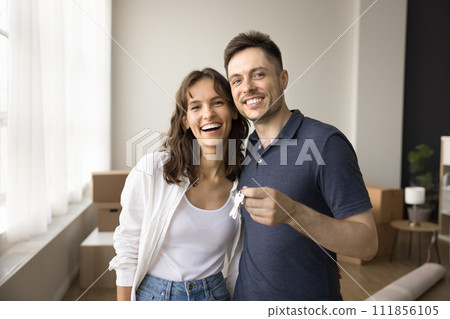 Couple of new home owners holding keys from new flat Couple of new home owners holding keys from new flat 111856105