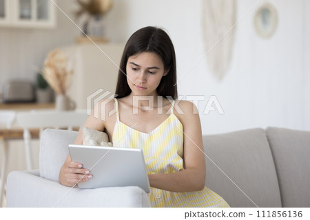 Serious young 25s pretty woman use modern digital tablet 111856136