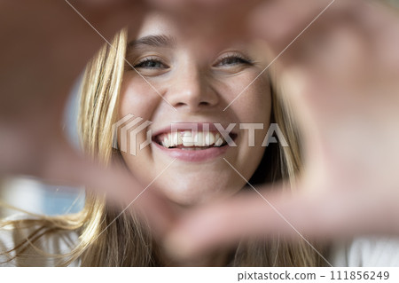 Close up portrait happy beautiful woman showing heart symbol Close up portrait happy beautiful woman showing heart symbol 111856249