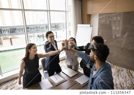 Cheerful multiethnic team of business colleagues giving group high five Cheerful multiethnic team of business colleagues giving group high five 111856347