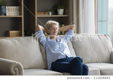 Silent peaceful middle-aged woman relaxing on sofa, take daytime break Silent peaceful middle-aged woman relaxing on sofa, take daytime break 111856691
