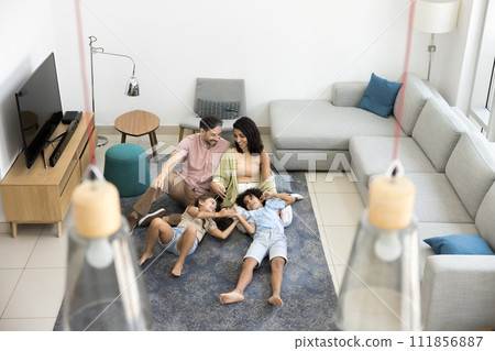 Two happy sibling kids and parents spending leisure at home Two happy sibling kids and parents spending leisure at home 111856887