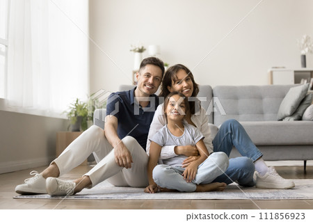 Cheerful family couple holding beautiful tween daughter girl in arms 111856923