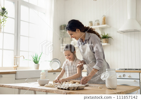 Woman teach daughter to cook, prepare homemade dough for pastries Woman teach daughter to cook, prepare homemade dough for pastries 111857142