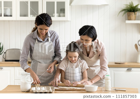 Multi generational women cooking together in the kitchen 111857303