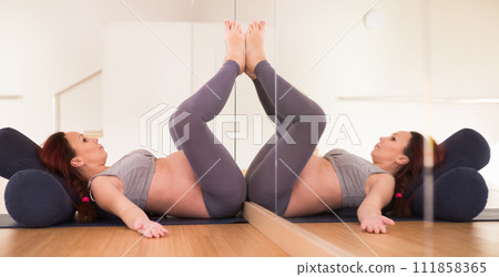 Pregnant woman is engaged in yoga. Bent Candle Pose or Viparita Karani 111858365