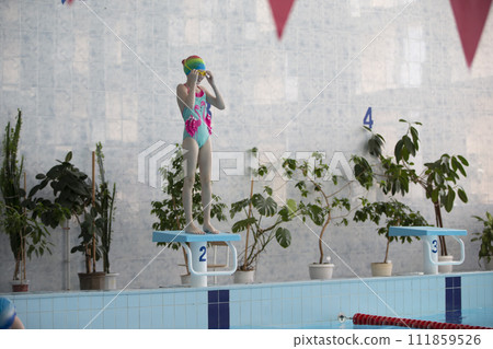Girls in a swimsuit and a swimming cap in the sports pool. 111859526