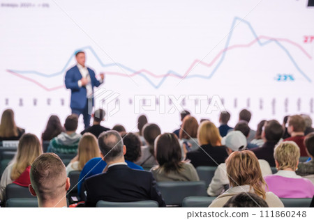 Confident speaker at business conference presenting growth charts 111860248