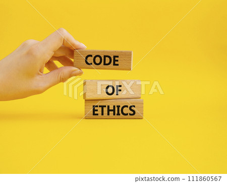 Code of ethics symbol. Concept words Code of ethics on wooden blocks. Beautiful yellow background. Businessman hand. Business and Code of ethics concept. Copy space. 111860567
