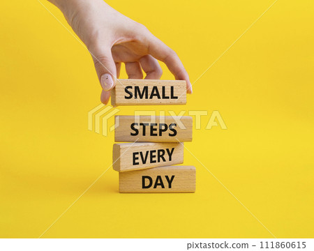 Small Steps Every Day symbol. Wooden blocks with words Small Steps Every Day. Beautiful yellow background. Businessman hand. Business and Small Steps Every Day concept. Copy space. 111860615