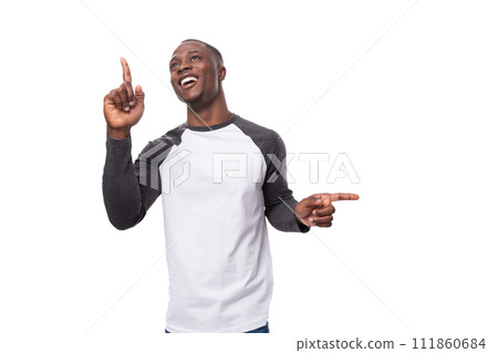 young positive african man dressed in a spring jacket points his finger to the side young positive african man dressed in a spring jacket points his finger to the side 111860684