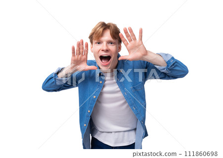 young confident european guy with golden hair dressed in a blue denim shirt over a white t-shirt young confident european guy with golden hair dressed in a blue denim shirt over a white t-shirt 111860698