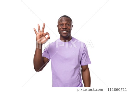 close-up portrait of a young laughing african man in a lilac t-shirt making a grimace close-up portrait of a young laughing african man in a lilac t-shirt making a grimace 111860711