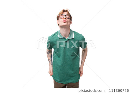 young bright ginger man with a tattoo on his arm dressed in a green short-sleeved T-shirt sends an 111860726