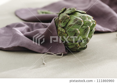 Fresh artichoke in purple linen bag. Healthy food cooking ingredients background with fresh vegetables Fresh artichoke in purple linen bag. Healthy food cooking ingredients background with fresh vegetables 111860960
