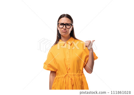 a young well-groomed woman with black straight hair dressed in a yellow dress points her finger to a young well-groomed woman with black straight hair dressed in a yellow dress points her finger to 111861028