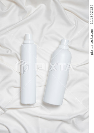 Liquid laundry detergent and fabric softener on a bed, vertical top view Liquid laundry detergent and fabric softener on a bed, vertical top view 111862125