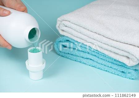 The process of pouring natural eco gel liquid laundry detergent from the bottle into the cap The process of pouring natural eco gel liquid laundry detergent from the bottle into the cap 111862149