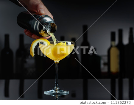 Cocktail Sidecar on a black table in a bar. Cocktail Sidecar on a black table in a bar. 111862273
