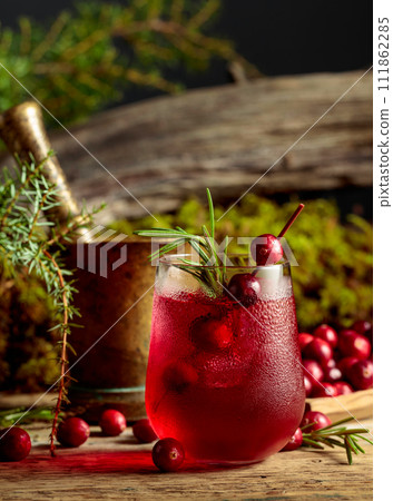 Cranberry cocktail with natural ice and rosemary in frozen glass. Cranberry cocktail with natural ice and rosemary in frozen glass. 111862285