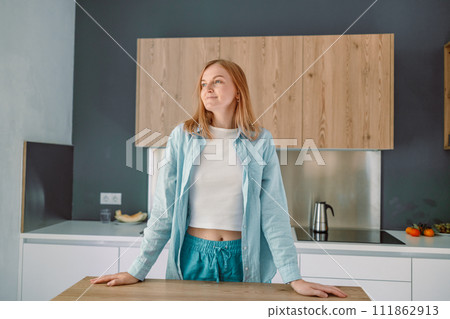 Woman with crossed hands standing behind countertop looking at the camera 111862913