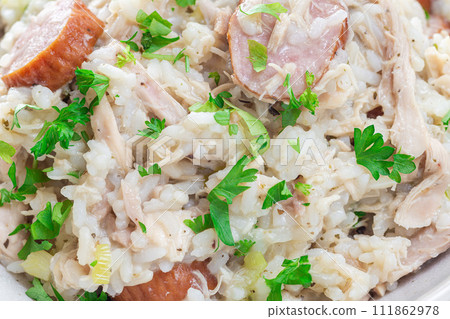 Traditional South Carolina chicken bog dish with smocked sausages, closeup in bowl, horizontal 111862978