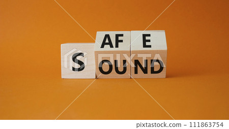 Safe and Sound symbol. Turned wooden cubes with words Safe and Sound. Beautiful orange background. Business and Safe and Sound concept. Copy space 111863754