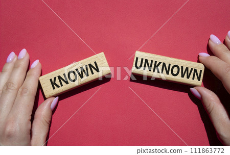 Known or Unknown symbol. Concept word Known or Unknown on wooden blocks. Businessman hand. Beautiful red background. Business and Known or Unknown concept. Copy space Known or Unknown symbol. Concept word Known or Unknown on wooden blocks. Businessman hand. Beautiful red background. Business and Known or Unknown concept. Copy space 111863772