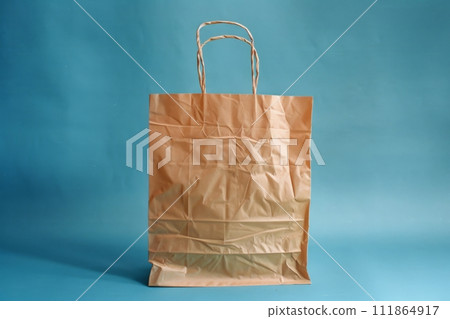 Paper shopping bag isolated on blue background 111864917