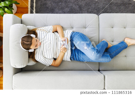 Relaxed Woman Listening to Music on Couch Relaxed Woman Listening to Music on Couch 111865316