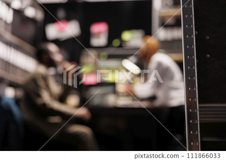 Blurred law enforcement professionals partners conducting investigation in private detective agency office. Two defocused man and woman investigators searching crime solving solution 111866033